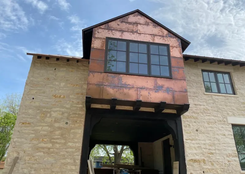 Copper metal panel facade on a stone building for Roof Repair in North Olmsted